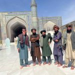 David Simpson with local people standing infront of the mosque in Herat, Afghanistan. Camels, rolling & sleep ‘n fly