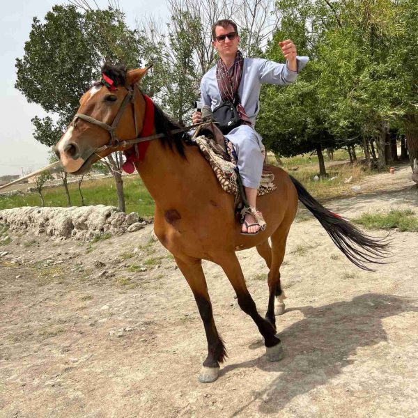 David Simpson riding horse in Mazar, Afghanistan. Playing volley ball with the Taliban