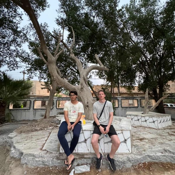 David Simpson seated with local at Garden of Eden in Iraq. Private tour of Saddam's yacht