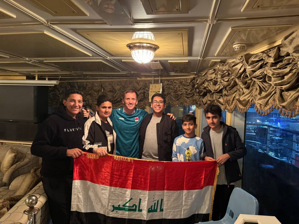 David Simpson and locals holding flag inside of Saddam's yacht in Basra in Iraq. Iraq v Indonesia in Basra