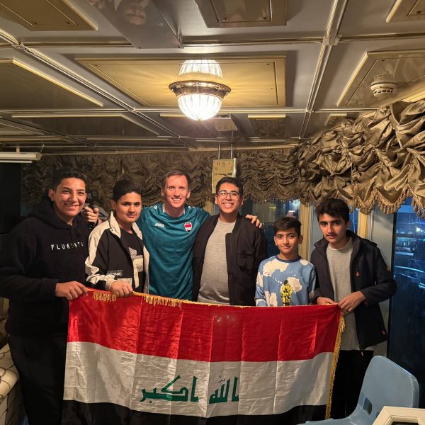 David Simpson and locals holding flag inside of Saddam's yacht in Basra in Iraq. Iraq v Indonesia in Basra